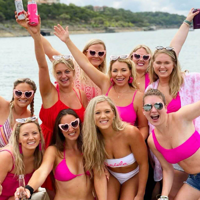 a group of people posing for a picture next to a body of water